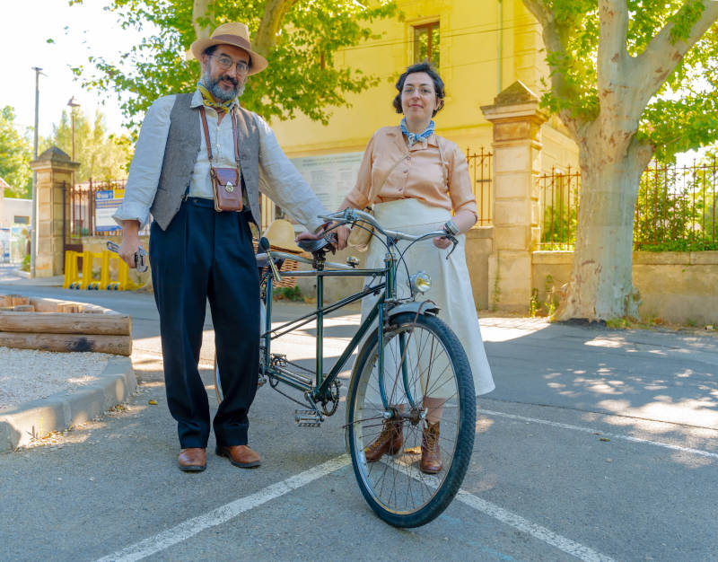 photo d'un couple en costumes années 1930 à côté d'un tandem