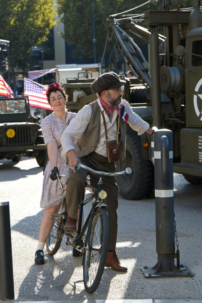 photo d'un couple en costumes années 1940 sur un tandem